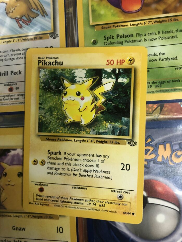 Pikachu Pokémon trading card on a table, surrounded by other Pokémon cards.