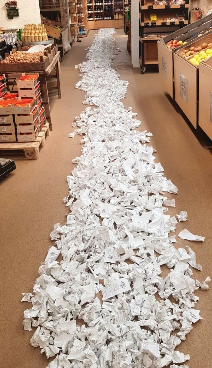 Interesting receipts scattered across a grocery store aisle, creating a long line of crumpled paper.