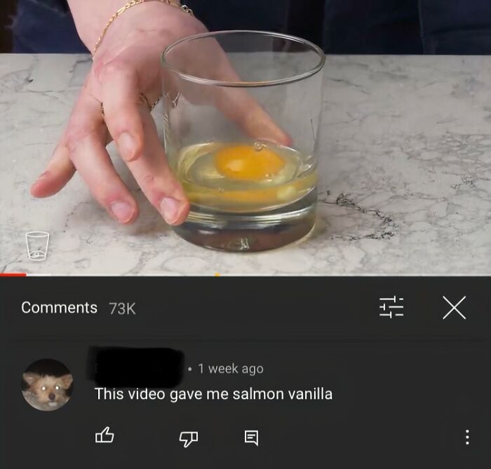 Hand holding a glass with a raw egg above a YouTube comment displaying a ridiculous spelling error.