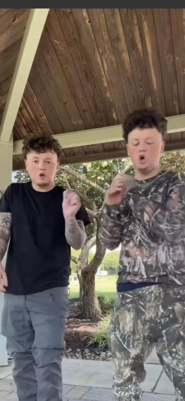 Two young men with unfortunate haircuts, one with a fade and the other with a messy top, posing outdoors.