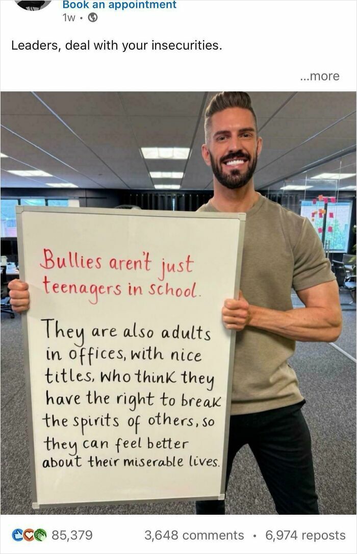 Man holding a sign about adult bullies in offices, highlighting "Recruiting Hell" experiences.