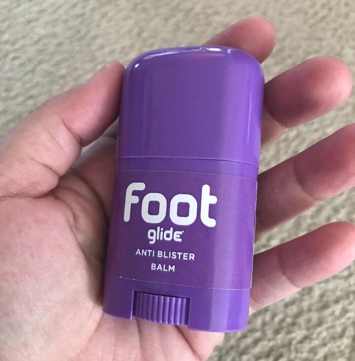 Purple anti-blister balm stick in hand, a problem-solving product to simplify daily life.