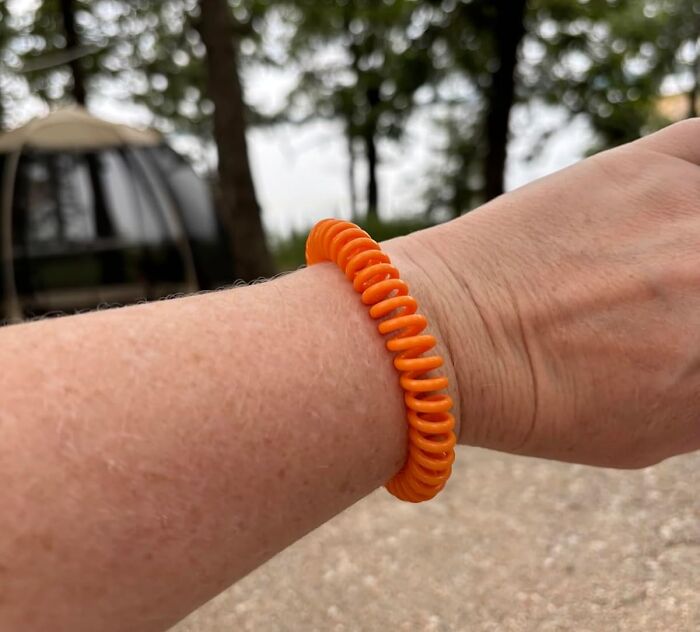 Orange coil wristband worn on a person's arm, exemplifying problem-solving products for daily life simplicity.