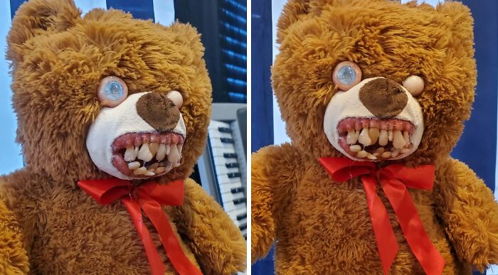 Creepy handmade teddy bear with unsettling eyes and teeth, wearing a red ribbon.