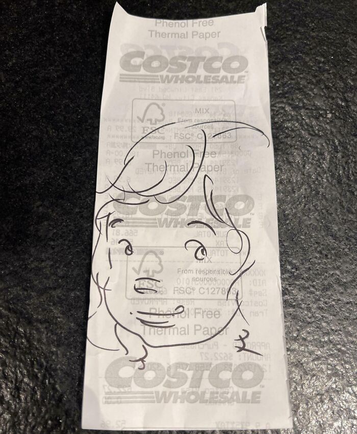 Costco receipt with an interesting doodle of a face drawn on it.