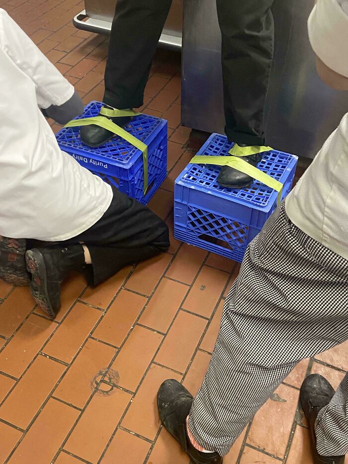 Creative footwear solutions in the food service industry, showing someone standing on crates.