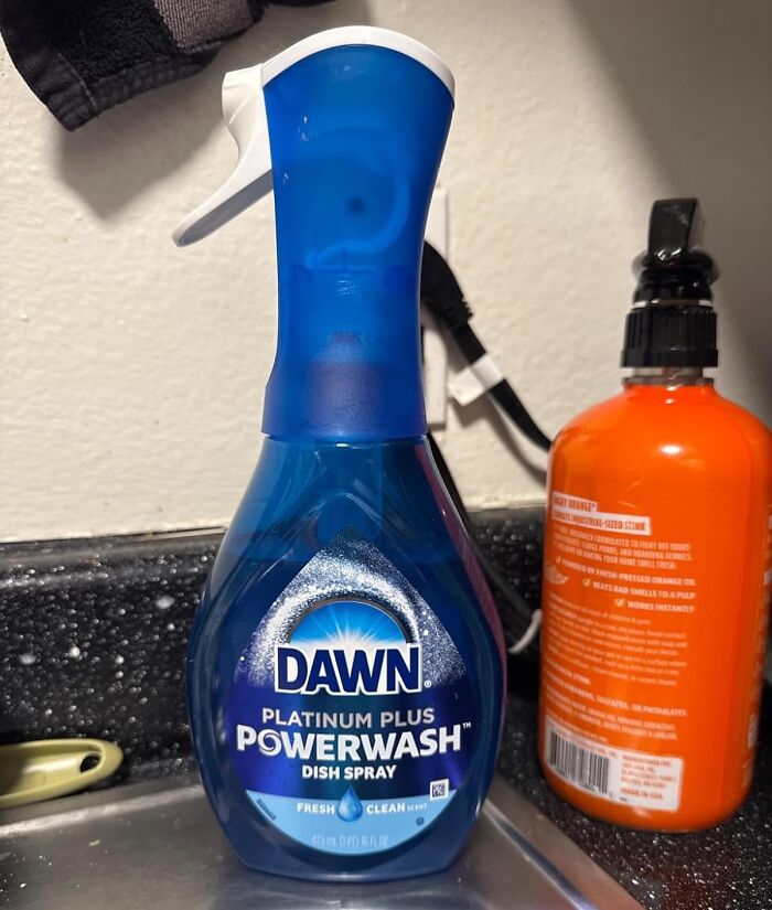 Dawn Platinum Powerwash dish spray, a notable impulse buy, on a black countertop near a sink.