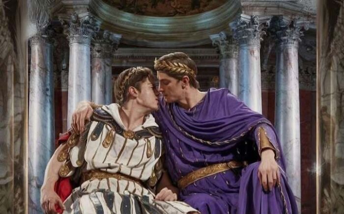 Two historical figures in Roman attire sharing a moment in a grand ancient setting.