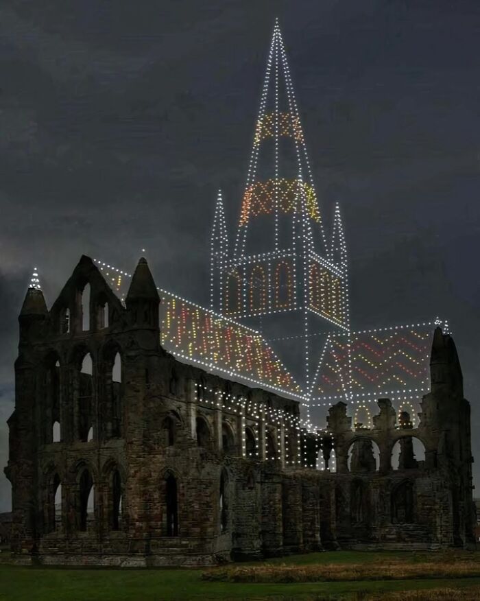 Historical ruins with illuminated outlines of lost architecture against a dark sky, highlighting an interesting past event.