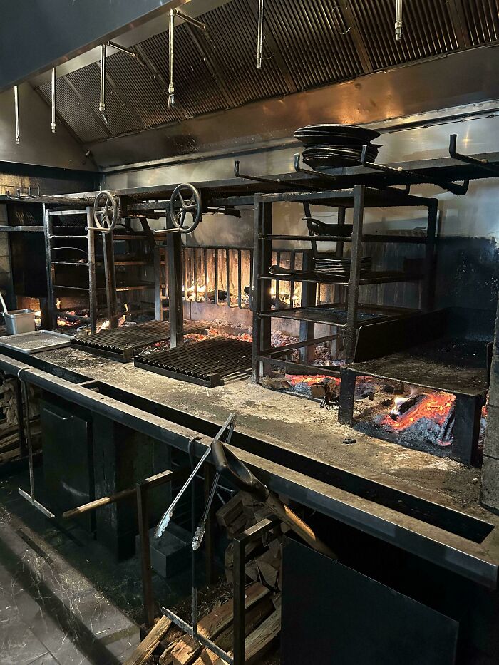 Industrial kitchen with open flame grills, depicting the food service industry environment.