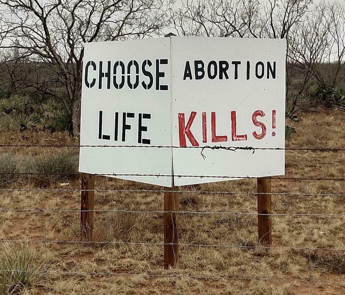 Sign in a field with a confusing message about life and abortion, illustrating a sign fail.