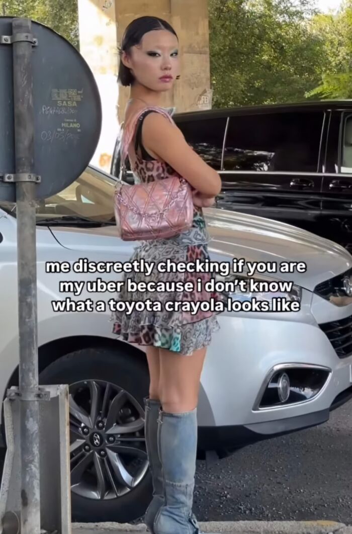 Young woman standing by a car with a humorous text overlay, embodying relatable just girly things meme.