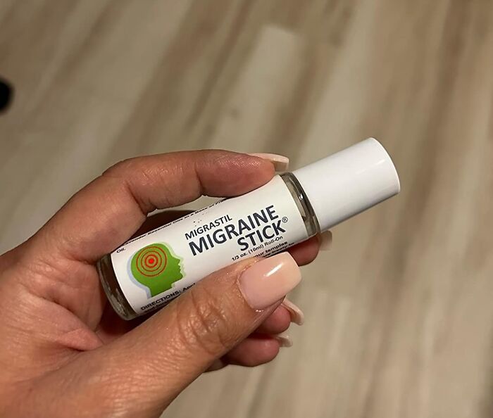 A hand holding a Migraine Stick, a mini item ideal for minimalist packing.