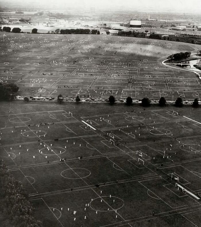 Aerial view of numerous soccer fields in an expansive park, showcasing an interesting moment in history.