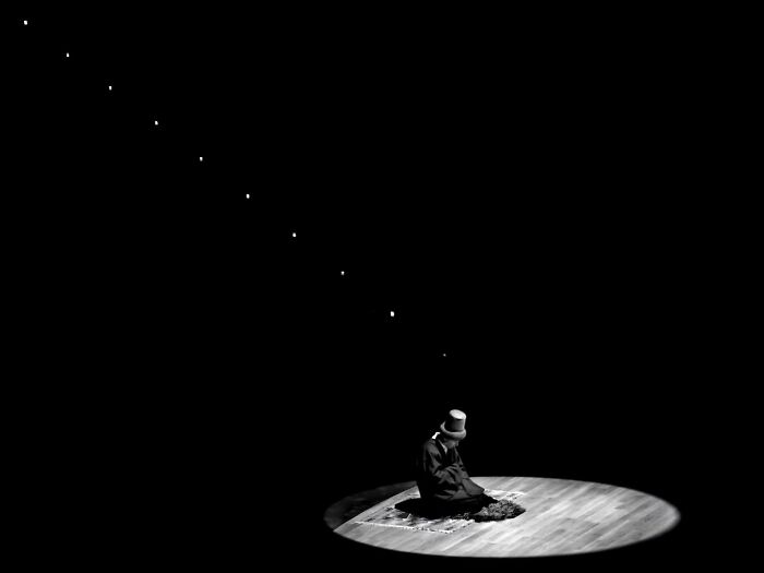 Monochrome scene of a person at center stage under spotlight, portraying rural Turkey in black-and-white photography.