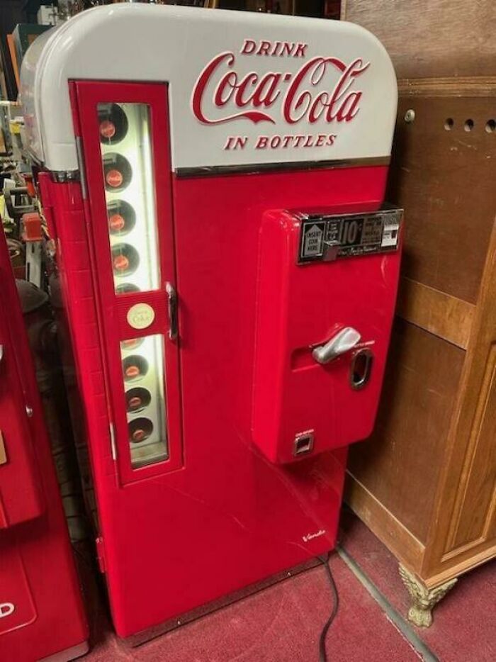 Vintage red Coca-Cola bottle vending machine from nostalgic pics collection showing retro design and coin operation.