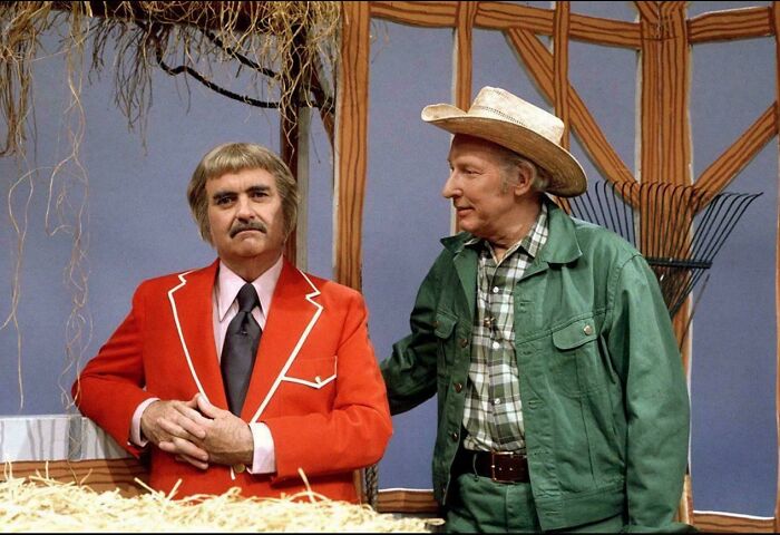 Two older men in vintage clothing on a nostalgic set, evoking memories from classic TV shows and past eras.