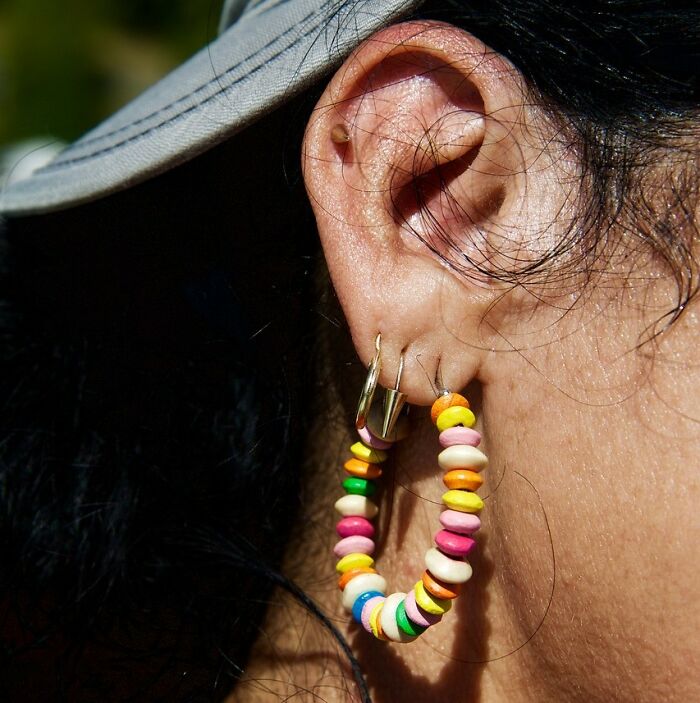 Close-up of a unique ear piercing showcasing colorful ring jewelry, exemplifying rare and unusual cosmetic procedures.