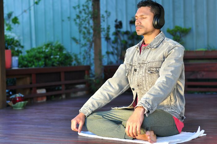 Person meditating with headphones outdoors, symbolizing knowledge and mindset change in therapy.