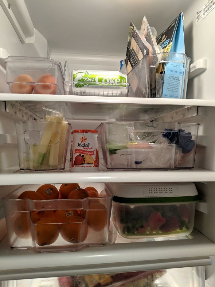 Organized refrigerator shelves with fresh produce and drinks for a spring cleaning headstart.