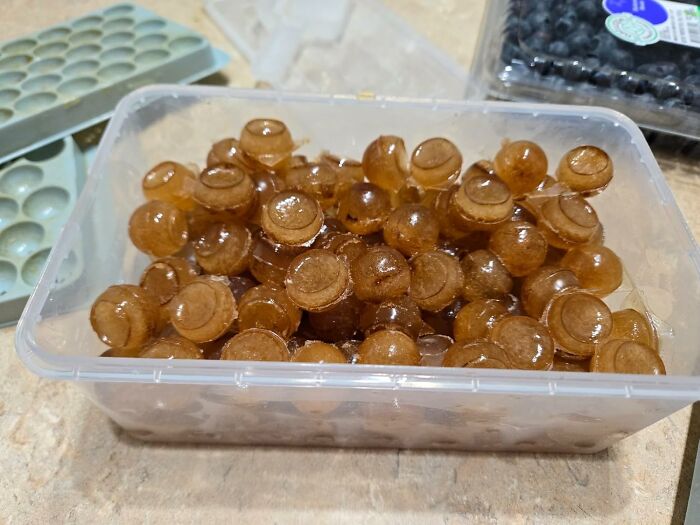 Hard-working brown lozenges neatly stored in a clear plastic container, showcasing things that work hard and look good.