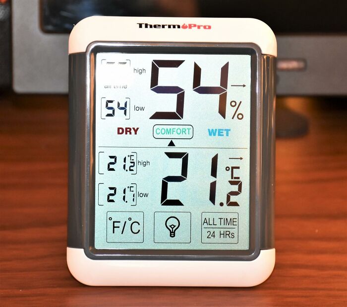 Digital hygrometer showing 54% humidity and 21.2°C temperature, essential for indoor gardening.
