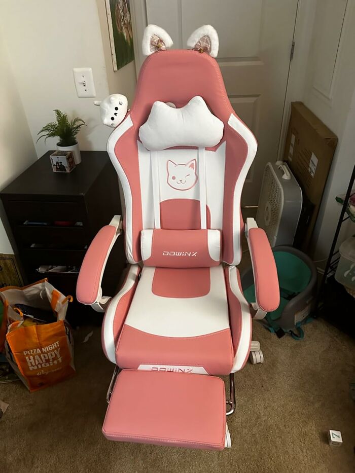 Pink and white cat-themed gaming chair with headrest and footrest in a home office space showing things that work hard.