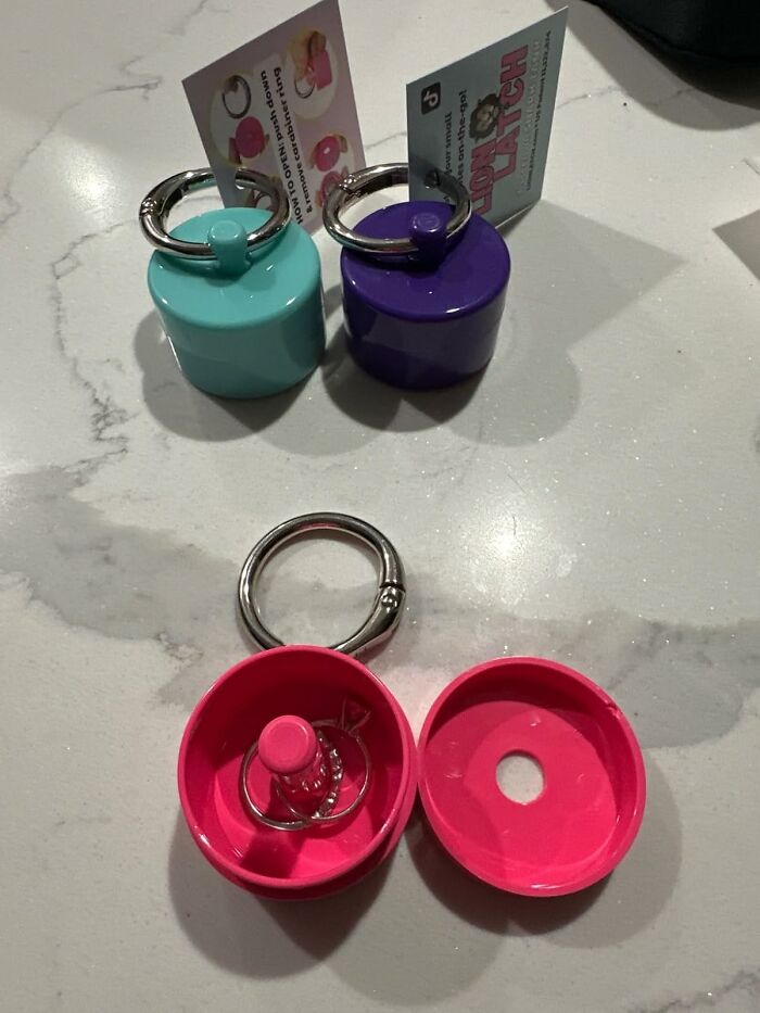 Colorful keychain gadgets from Sharktank, including pink, teal, and purple designs on a marble surface.