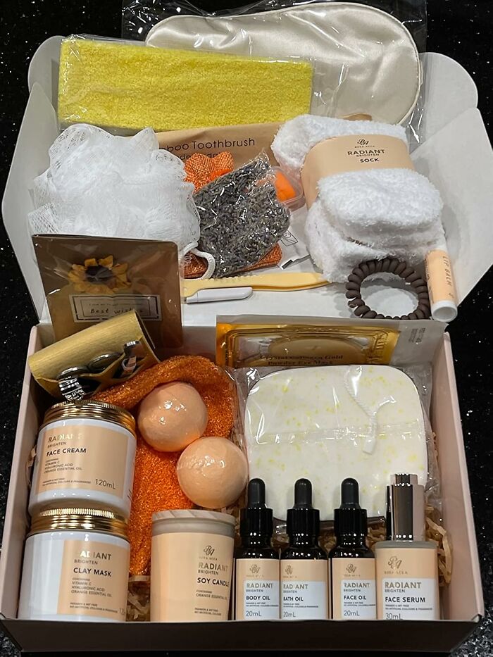 Spa gift box with face cream, clay mask, bath oils, body oil, face serum, socks, and self-care accessories for fun date night ideas.