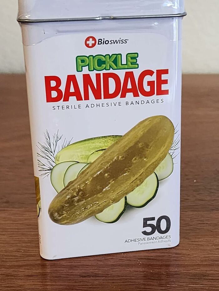 Pickle bandage tin on a table, featuring 50 adhesive bandages for adding some goofiness to your day.