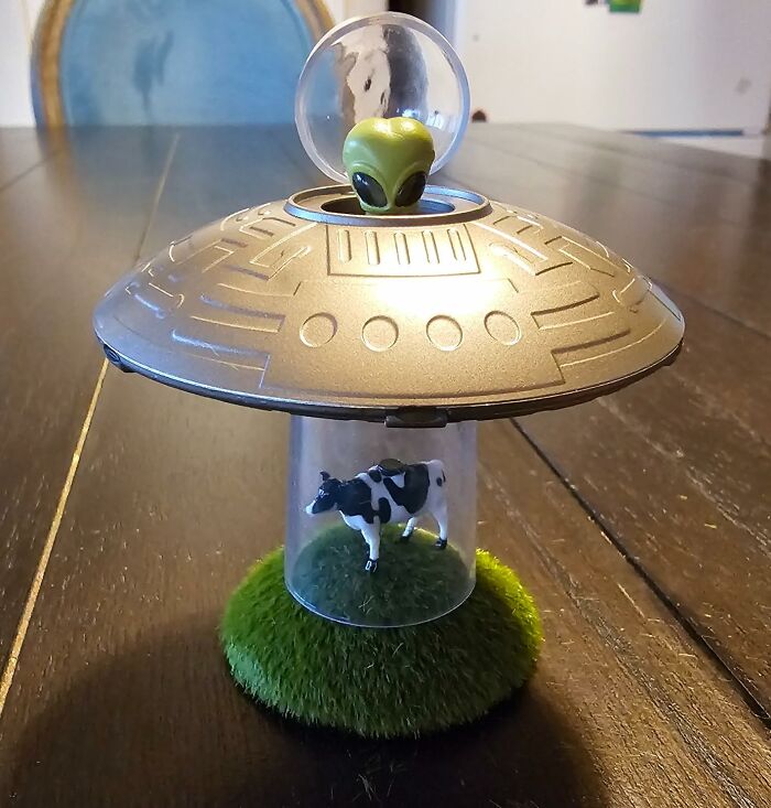 Toy UFO with alien, displaying a cow being abducted, a cult favorite item.