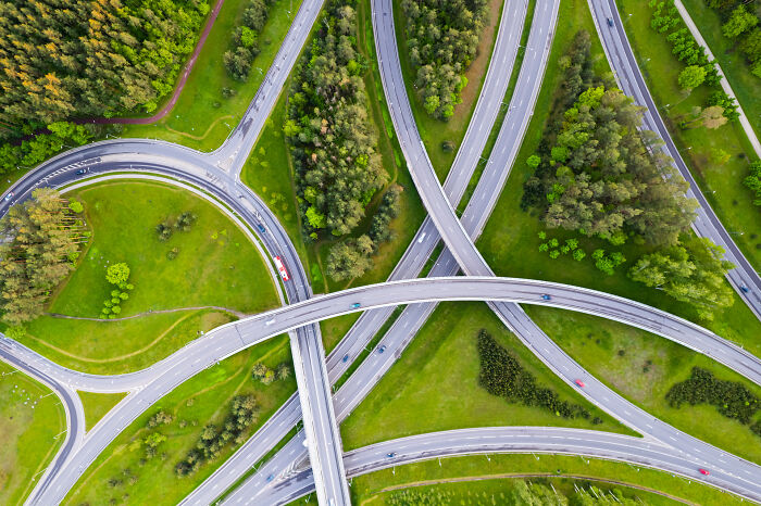Bird's-eye view of a highway interchange surrounded by lush green landscape in Lithuania.