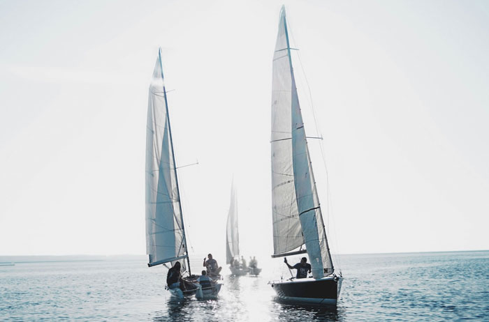 Sailboats on a sunny day, highlighting rich people's lifestyle on the water.