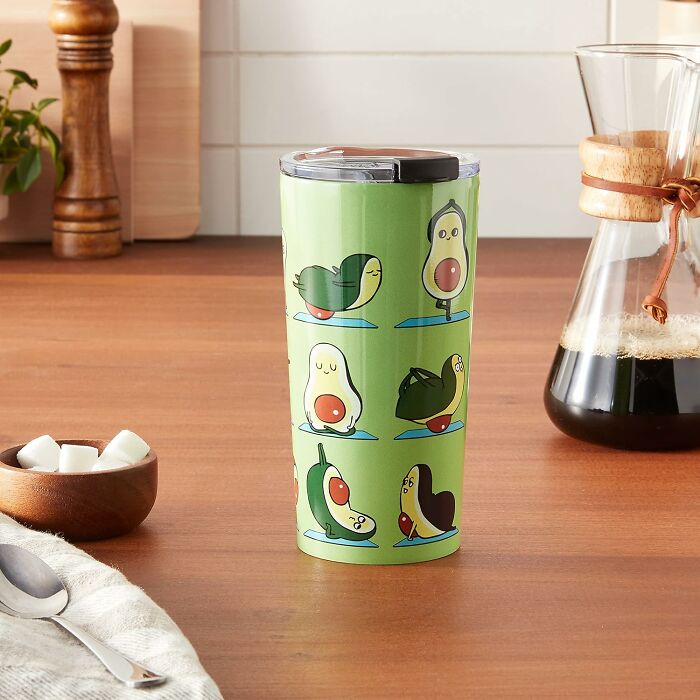Society 6 tumbler featuring cute avocado yoga illustrations on a wooden kitchen counter.