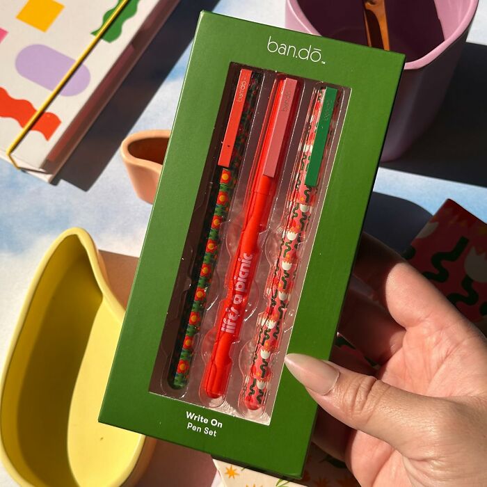 Bando pen set in colorful packaging held in hand, showcasing vibrant design.
