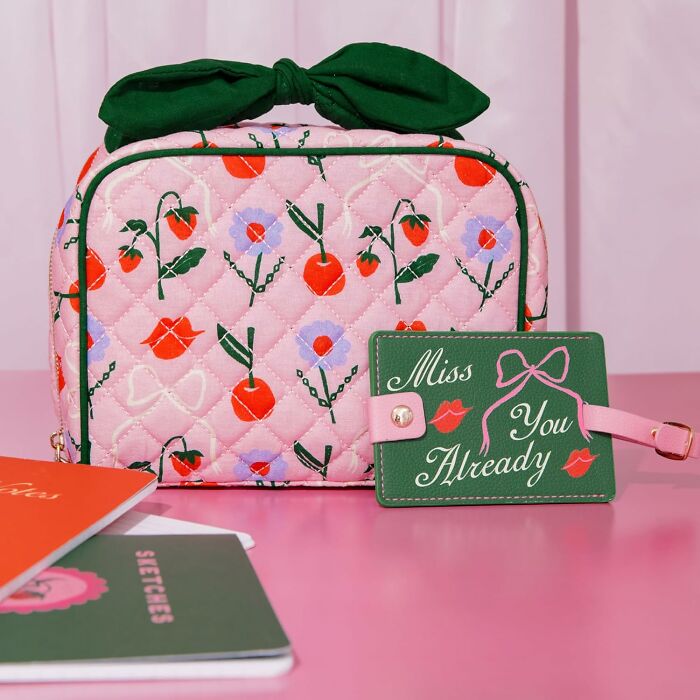 Bando floral makeup bag with matching "Miss You Already" tag on a pink surface.