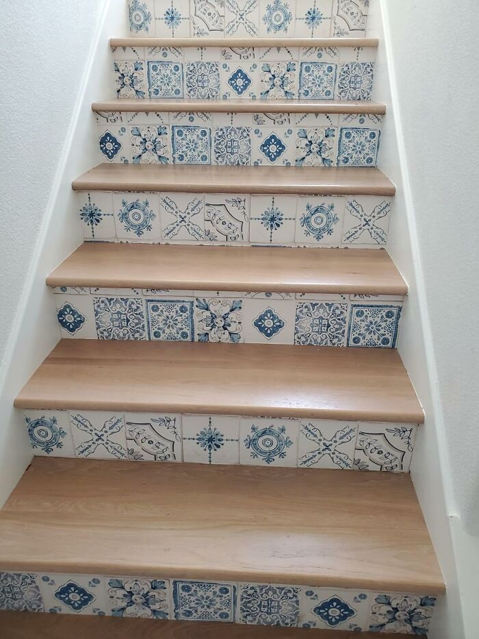 Staircase with wooden steps and decorative blue and white patterned tiles, showcasing things that work hard and look good.