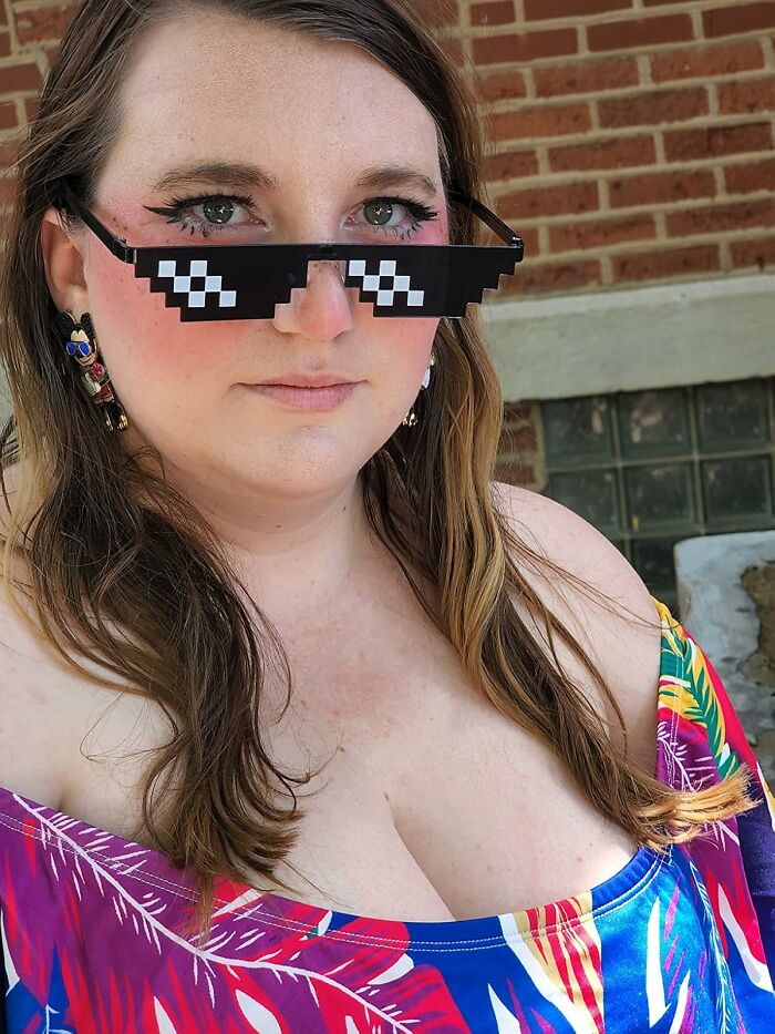 Person wearing pixelated sunglasses and a colorful top, showcasing one of the weird things that actually exist.