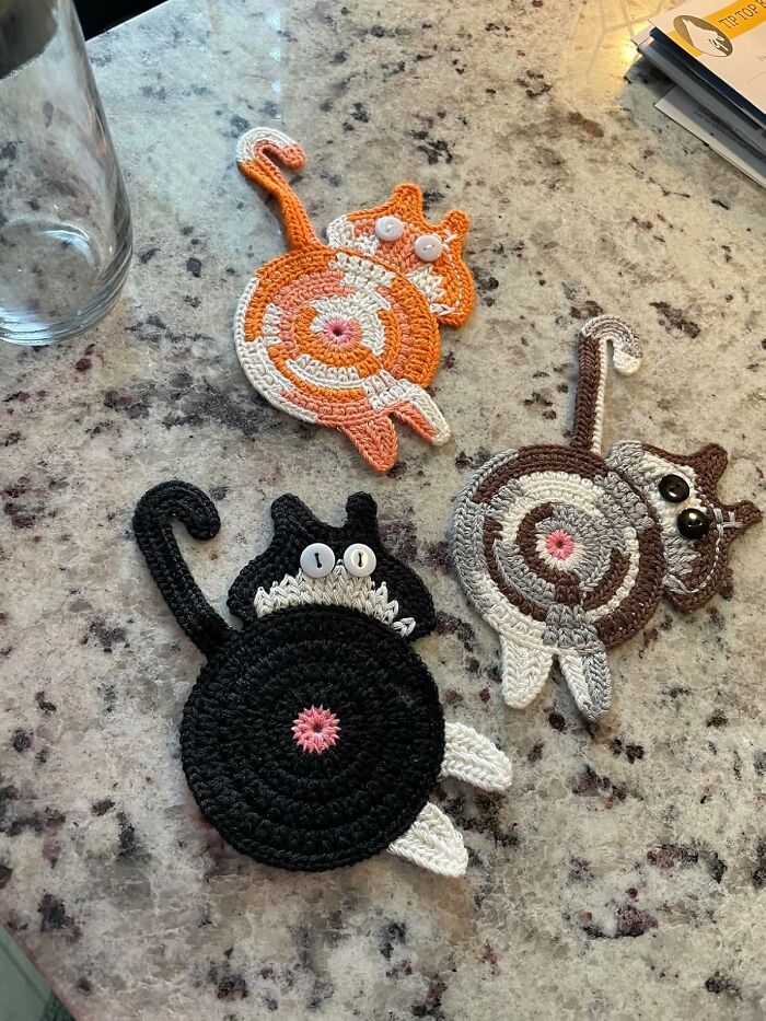 Crocheted cat coasters on a countertop, adding a touch of goofiness to the kitchen decor.