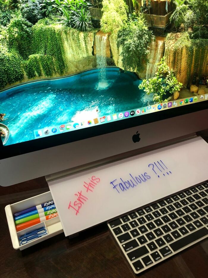 iMac displaying a waterfall scene, with keyboard and colorful markers, essential for work from home tech setup.