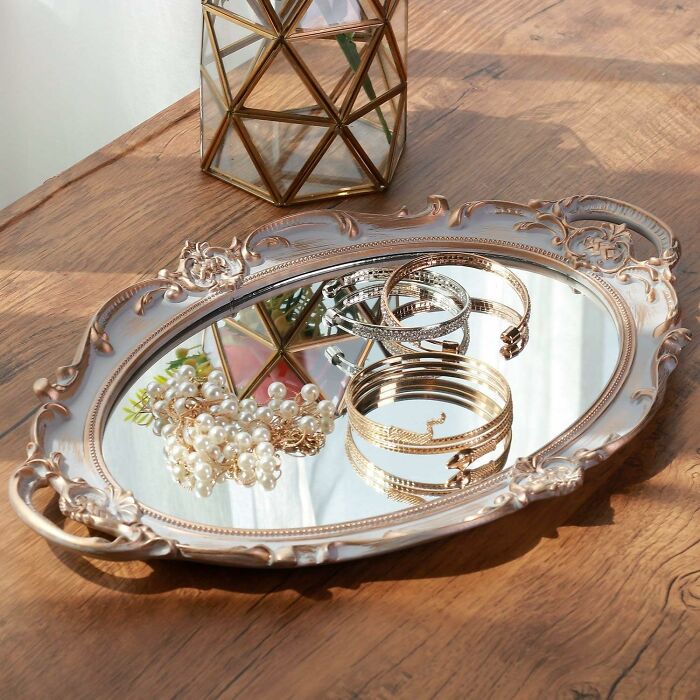 Ornate tray with elegant bracelets and pearl necklace reflecting expensive taste on a humble budget setting.