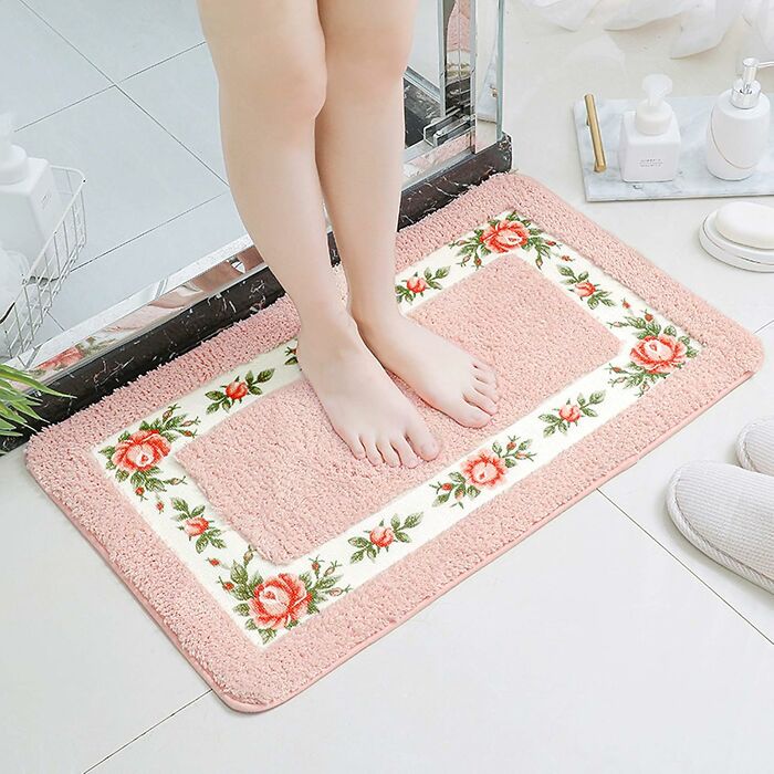 Person standing on a pink floral bathroom mat with soft texture enhancing bathroom mats style and comfort.