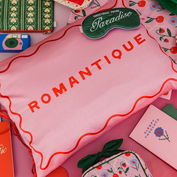 Bando pillow with Romantique text, surrounded by colorful accessories.