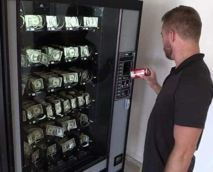 Hombre frente a una máquina expendedora «rara» llena de billetes, sosteniendo una lata de refresco.