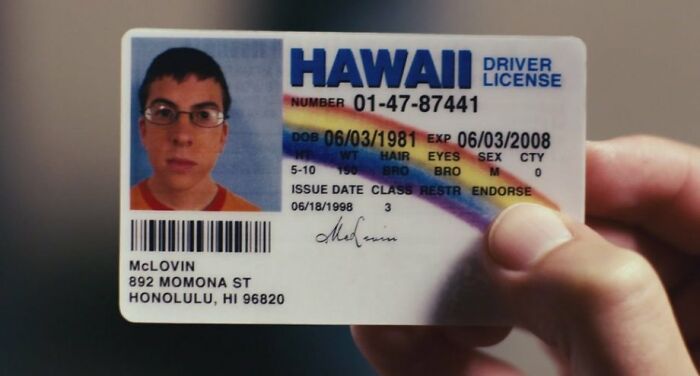 "Hawaii driver's license prop from a famous movie, held between fingers, showcasing unique story details."