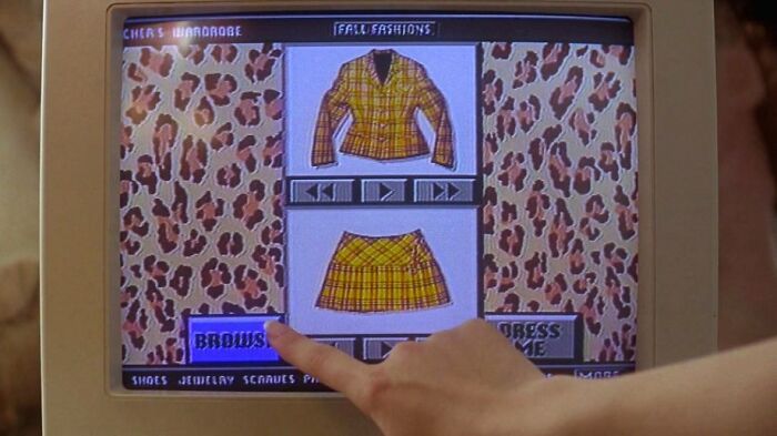 Person using a computer to browse famous movie props, showing a plaid outfit on screen.