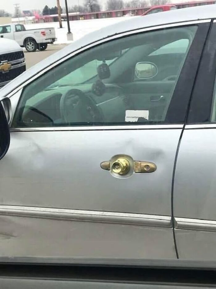 Silver car with a door k**b installed on the door handle, showcasing a weird image.