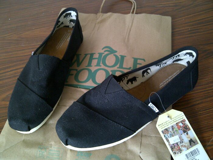 Black canvas shoes on a Whole Foods bag, promoting "Songs As Ringtones" concept with eco-friendly packaging.