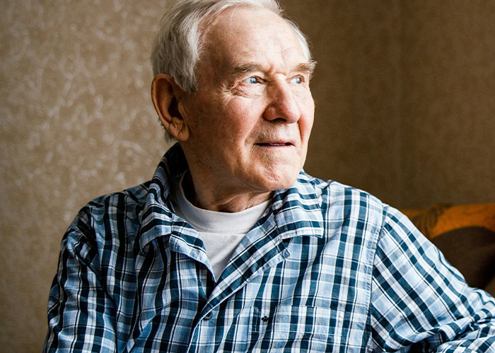 Elderly man in a plaid shirt looking pensive; capturing heartfelt moments.