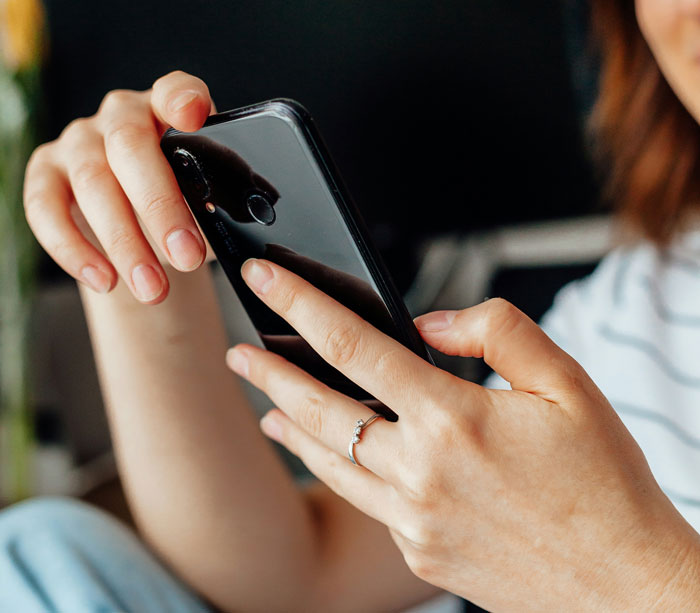 Woman researching a background on her smartphone, highlighting investigative curiosity.